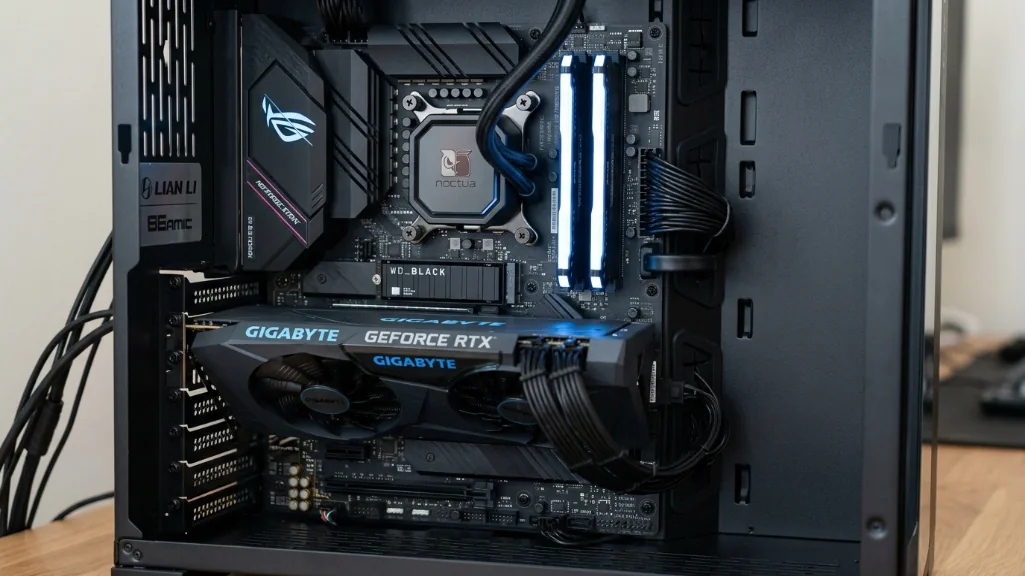 inside view of gaming PC showing standard ATX motherboard, graphics card, RAM, and cable management with RGB lighting