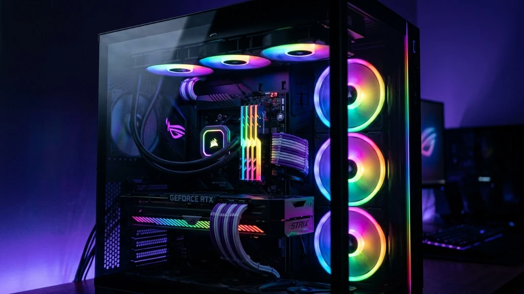 RGB gaming PC interior with synchronized rainbow lighting from multiple fans and components through tempered glass panel
