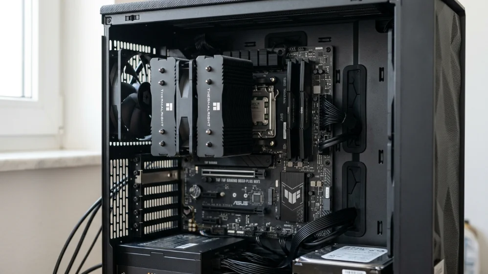 Ryzen 7 9800X3D installed in AM5 motherboard with tower air cooler inside mid-tower PC case showing practical budget cooling solution