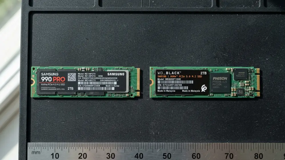 PCIe 4.0 and PCIe 5.0 M.2 NVMe SSD drives side by side on anti-static mat showing identical form factor with different controller chips
