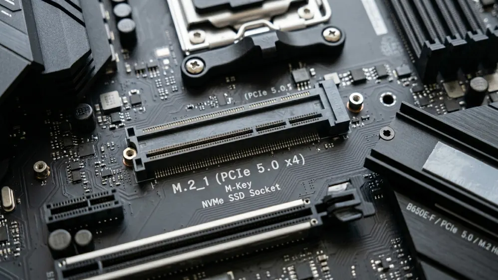 Close-up of M.2 PCIe 5.0 slot on AM5 motherboard with heatsink removed showing slot label and NVMe contacts