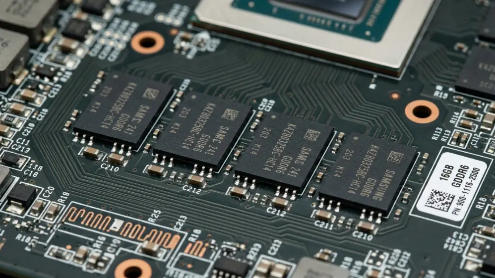 Close-up macro photo of GDDR6 VRAM memory chips on AMD RX 9070 XT graphics card PCB showing 16GB memory configuration