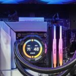 Inside a gaming PC: an AIO pump block with a round temperature display mounted on the CPU socket, braided tubes running to a top-mounted radiator, with the motherboard VRM heatsinks around the socket