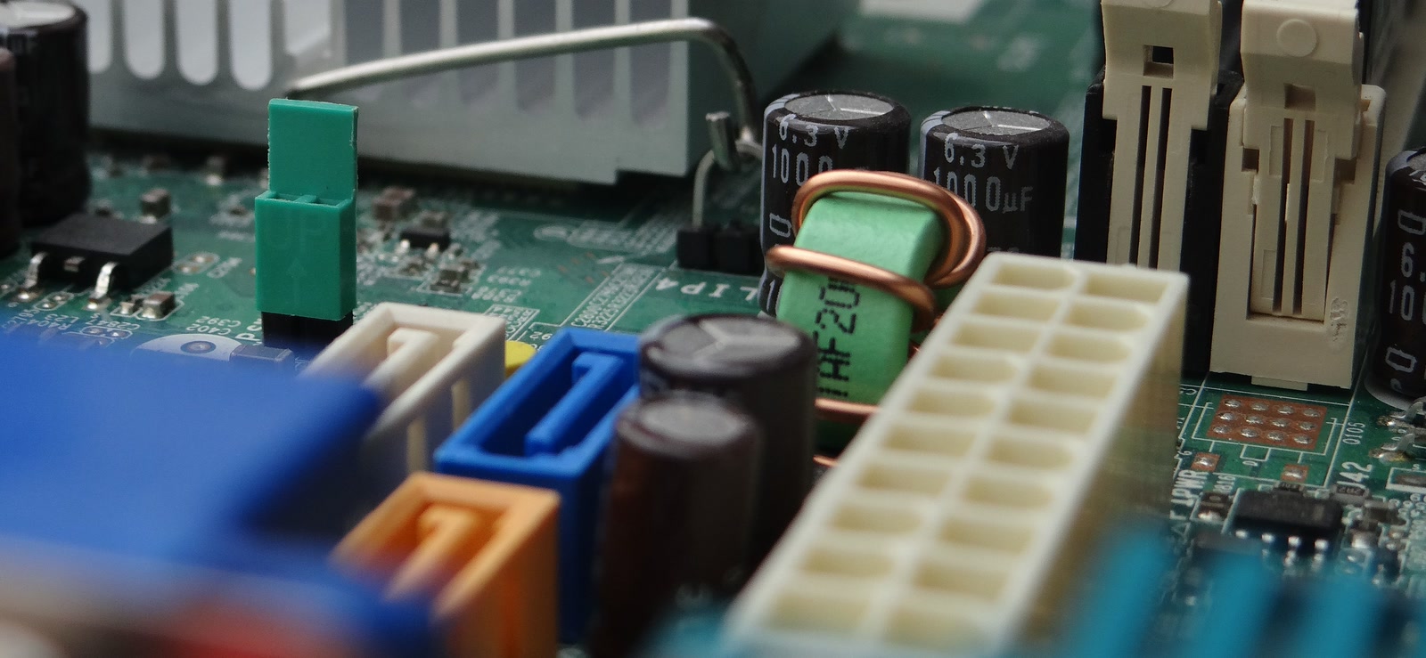 Close-up of a desktop motherboard showing the power connector, SATA ports and memory slots